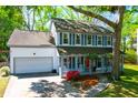 Inviting two-story house with a cozy front porch, bright red door, and attached garage at 1255 Horseshoe Bnd, Mount Pleasant, SC 29464