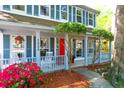 Charming front porch with rocking chairs, vibrant azaleas, and a bright red front door at 1255 Horseshoe Bnd, Mount Pleasant, SC 29464