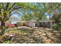 Lovely single-story home with a well-manicured lawn, mature trees, and flowering bushes at 1411 River Front Dr, Charleston, SC 29407