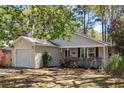 Well-maintained single-story home with vinyl siding, an attached garage, and a landscaped front yard at 1411 River Front Dr, Charleston, SC 29407