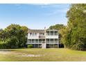 Rear elevation of a coastal home with multi-level decks and lush surrounding greenery at 1651 Atlantic Ave, Sullivans Island, SC 29482