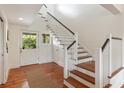 Entryway with wood floors, staircase, and natural light from the exterior door at 1651 Atlantic Ave, Sullivans Island, SC 29482