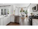 Modern kitchen featuring stainless steel appliances, dark hardwood floors, white cabinets, and an adjacent dining area at 195 Belfort Pl, Summerville, SC 29486