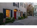 Charming entrance featuring a red door, decorative window, and vibrant flower boxes at 2 Bedons Aly, Charleston, SC 29401