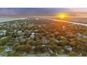 Scenic aerial view showcasing the beautiful neighborhood with the ocean and a stunning sunset at 2 Wills Way, Isle of Palms, SC 29451