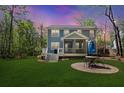 The backyard features a patio with a table, umbrella, green grass, and a covered porch at 2111 Nicholas David Path, Johns Island, SC 29455
