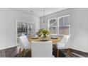 Bright dining room features a modern pendant light, wood table, and access to the screened in porch at 225 Denham St, Summerville, SC 29486