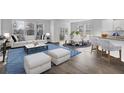 The living room and kitchen in an open floorplan are filled with bright, natural light and modern finishes at 225 Denham St, Summerville, SC 29486