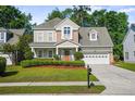 Traditional home featuring a manicured lawn, a two-car garage, and a covered front porch at 225 Silverwood Ln, Summerville, SC 29485