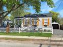 Quaint house with shuttered windows and flower boxes, set behind a white picket fence and featuring a detached garage at 2313 Kent Ave, North Charleston, SC 29405