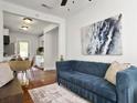 Comfortable living room with a plush blue sofa, hardwood floors, and an open layout connected to the dining area at 2313 Kent Ave, North Charleston, SC 29405