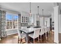Bright kitchen features a large island, pendant lighting, white cabinets and stainless appliances at 2340 Salt Wind Way, Mount Pleasant, SC 29466