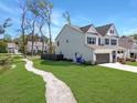Side view of a two-story house with a sidewalk, green lawn, and view of a pond at 2823 Dearmin Dr, Mount Pleasant, SC 29466
