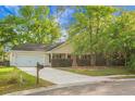 Well-kept single-story house featuring beautiful landscaping, mature trees, and a convenient two-car garage at 301 Huntington Ct, Hanahan, SC 29410