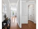 Inviting hallway with hardwood floors, white molding, leading to a bright living area and other rooms at 408 Branch Creek Trl, Summerville, SC 29483