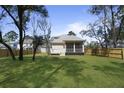 Expansive backyard featuring lush grass, mature trees, and a screened porch at 4209 Royal Harbor Rd, Hollywood, SC 29449