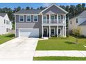 Inviting home exterior featuring a charming front porch and well-maintained lawn at 4310 Cotton Flat Rd, Summerville, SC 29485