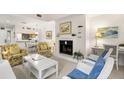 Comfortable living room with fireplace, floral armchairs, and a view into the adjacent kitchen area at 4338 Sea Forest Dr, Kiawah Island, SC 29455