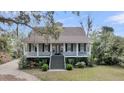 Charming two-story home with a inviting porch, lovely landscaping, and stairs leading to the entrance at 4584 Olde Smoak House Rd, Meggett, SC 29449