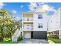 Bright, modern three-story house featuring double balconies and staircase leading to a garage at 5035 Gum Tree Ln, Johns Island, SC 29455