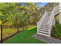 Well-maintained yard with metal fence and staircase to the home entrance at 5035 Gum Tree Ln, Johns Island, SC 29455