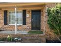 A classic front door with black shutters, complemented by green plants at 65 University Dr, Ladson, SC 29456