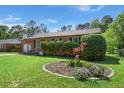 Landscaped front yard featuring a brick home, green lawn, and a flower bed at 65 University Dr, Ladson, SC 29456