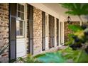 Close up on brick home exterior with dark shutters, white trim and covered porch with hanging lantern at 731 Pitt St, Mount Pleasant, SC 29464