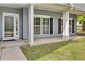 Inviting front entrance with white columns, large windows, and a storm door at the front door at 8001 Hydrangea Ln, Hanahan, SC 29410