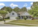 Inviting single-Gathering home with an attached garage, lush trees, and well-manicured landscaping at 8001 Hydrangea Ln, Hanahan, SC 29410