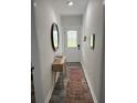 Hallway with a decorative mirror and a light wood console table on gray floors at 928 Sycamore Ave, Charleston, SC 29407