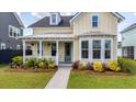 Charming home featuring a inviting porch, beautiful landscaping and a walkway leading to the front door at 113 Grimball St, Summerville, SC 29486