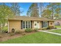 Traditional home featuring a manicured lawn, brick facade, black shutters, and simple landscaping at 123 Tiffany Ln, Summerville, SC 29485