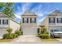Inviting townhouse featuring light beige siding, black shutters, and a convenient one-car garage at 1314 Garland St, North Charleston, SC 29420