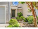 Charming entrance featuring a dark front door, lush landscaping, and neutral siding at 1314 Garland St, North Charleston, SC 29420