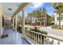 Inviting front porch with white railings and a hanging flower basket with vibrant colors at 141 Beaufain St, Charleston, SC 29401