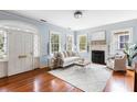 Bright living room with hardwood floors, fireplace, large windows, and elegant white furniture at 141 Beaufain St, Charleston, SC 29401