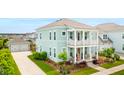A beautiful two-story home featuring a double porch, complemented by a detached two-car garage and lush landscaping at 144 Sandy Bend Ln, Summerville, SC 29486
