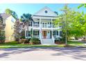 Charming two-story home with double front porches, red front door and beautifully landscaped yard at 147 Musket Loop, Summerville, SC 29483