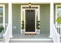Stylish front door with sidelights, topiaries and a welcoming mat, creating an inviting entrance at 1504 Galloway Ln, Charleston, SC 29412