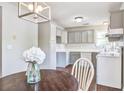 An eat-in kitchen with warm wood floors, grey cabinets, white appliances, and a pendant light at 1708 Eallystockert Rd, Charleston, SC 29414