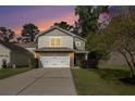 Charming two-story home with stone accents, attached two car garage, set against colorful dusk sky at 1723 Indaba Way, Charleston, SC 29414