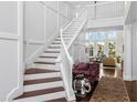Elegant foyer with a grand staircase, wainscoting, and views into the living room through large windows at 1749 James Basford Pl, Mount Pleasant, SC 29466