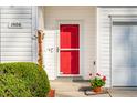 Close up of the red front door, showing the house number, Ring doorbell, and a potted flower arrangement at 1906 Cedar Petal Ln, Charleston, SC 29414