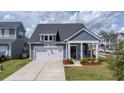 Inviting home showcases gray siding, a two-car garage, and a neatly manicured front lawn at 202 Morning Song St, Summerville, SC 29485