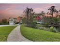 Picturesque neighborhood view featuring well-maintained homes, lush landscaping, and tranquil pond at 2242 Terrabrook Ln, Charleston, SC 29412