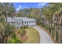 Aerial view of a house with a long driveway, surrounded by mature trees and lush landscaping at 26 Edgewater Aly, Isle of Palms, SC 29451