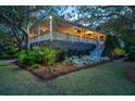 Charming home exterior with inviting porch and lush landscaping, offering a serene and picturesque setting at 2629 Goldbug Ave, Sullivans Island, SC 29482