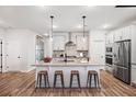 Bright, open kitchen featuring a large island with seating, stainless steel appliances, and modern white cabinetry at 265 Lucca Dr, Summerville, SC 29486