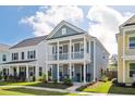 Beautiful two-story home with a welcoming double porch and manicured lawn on a sunny day at 2743 Calico Bass Ln, Johns Island, SC 29455